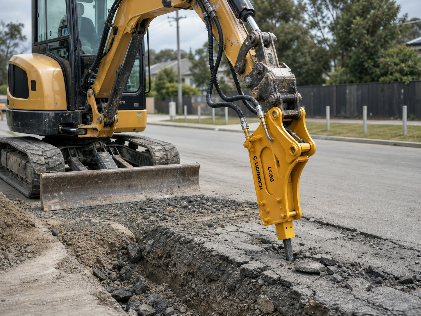 Backhoe loader with hydraulic breaker on a road worksite